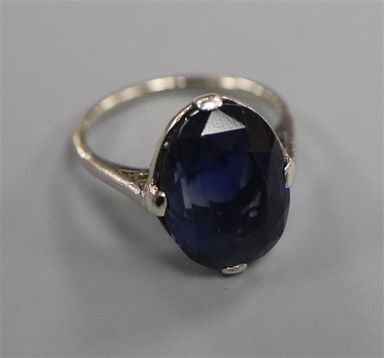 A white metal and oval synthetic? sapphire dress ring, size L.